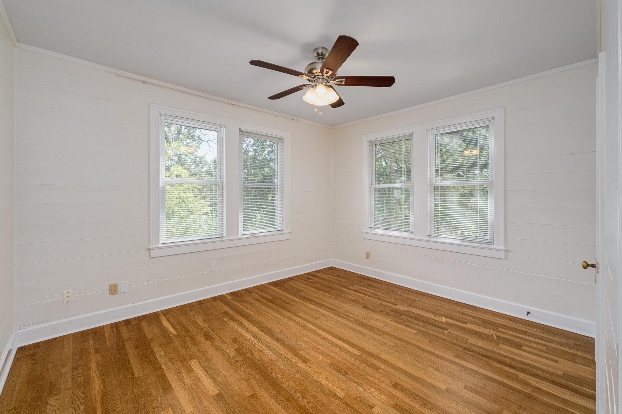 2012 Enfield Road, Unit B Austin, TX 78703 - Photo 13 of 20 Well-lit bedroom featuring multiple windows and classic wood flooring.