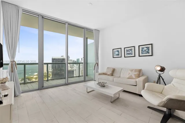 a living room with furniture and a floor to ceiling window