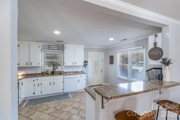 a kitchen with stainless steel appliances granite countertop a sink dishwasher and cabinets with wooden floor