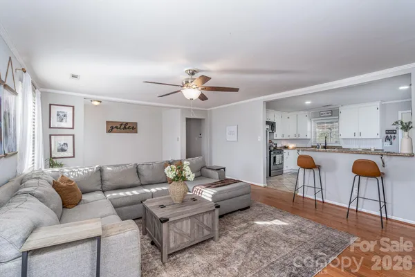 a living room with furniture and a dining table with kitchen view