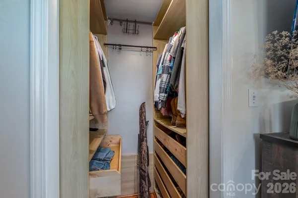 a view of walk in closet with clothes and shoes