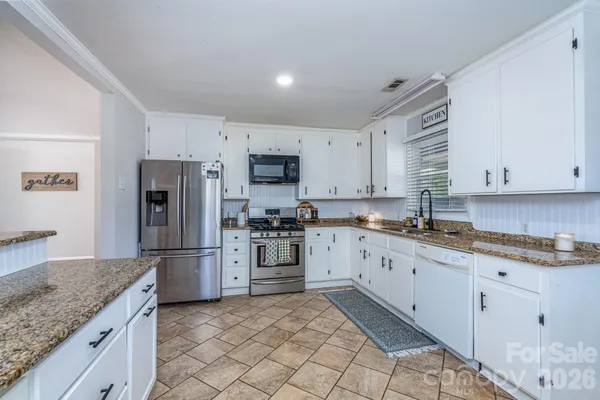 a kitchen with granite countertop cabinets stainless steel appliances and a counter space
