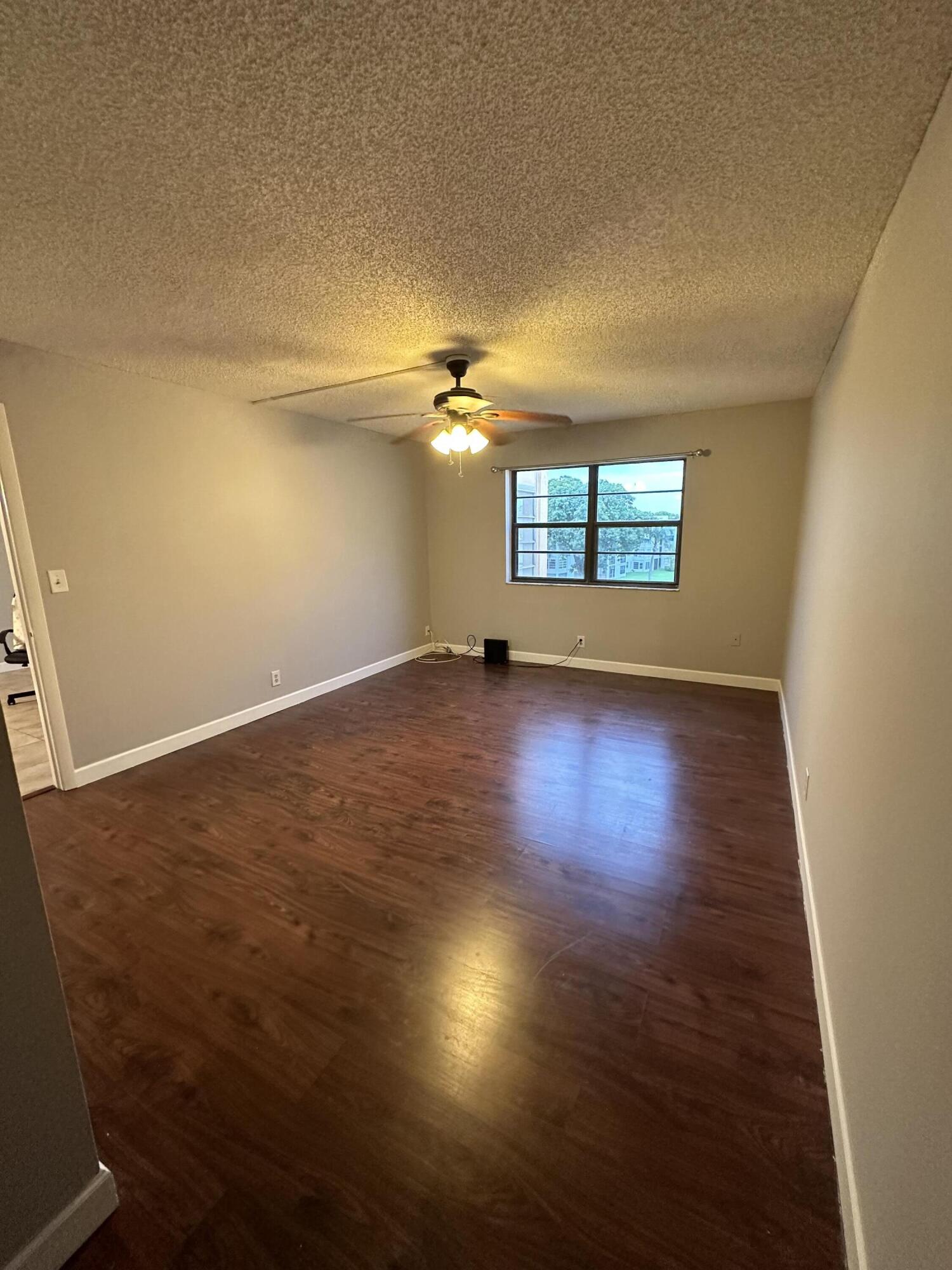 9370 Southwest 8th Street, Unit 419 Boca Raton, FL 33428 - Photo 13 of 18 an empty room with wooden floor and windows