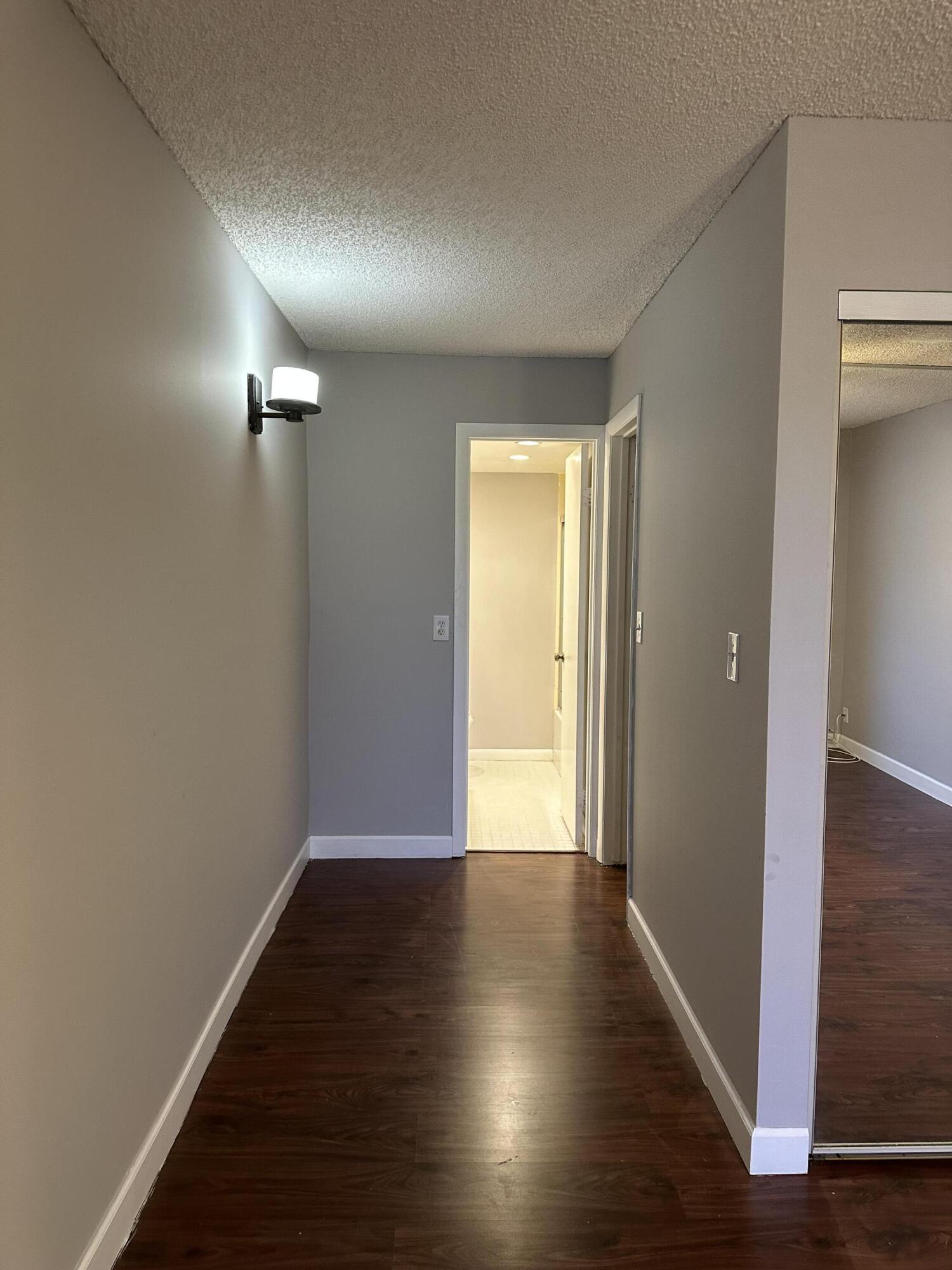 9370 Southwest 8th Street, Unit 419 Boca Raton, FL 33428 - Photo 14 of 18 a view of a hallway with wooden floor