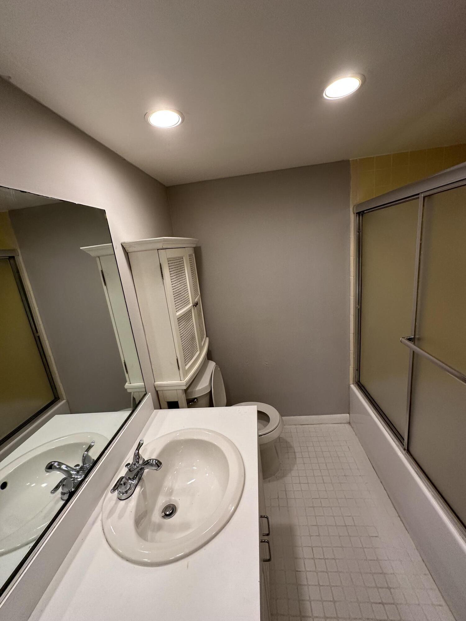 9370 Southwest 8th Street, Unit 419 Boca Raton, FL 33428 - Photo 16 of 18 a bathroom with a sink and a mirror