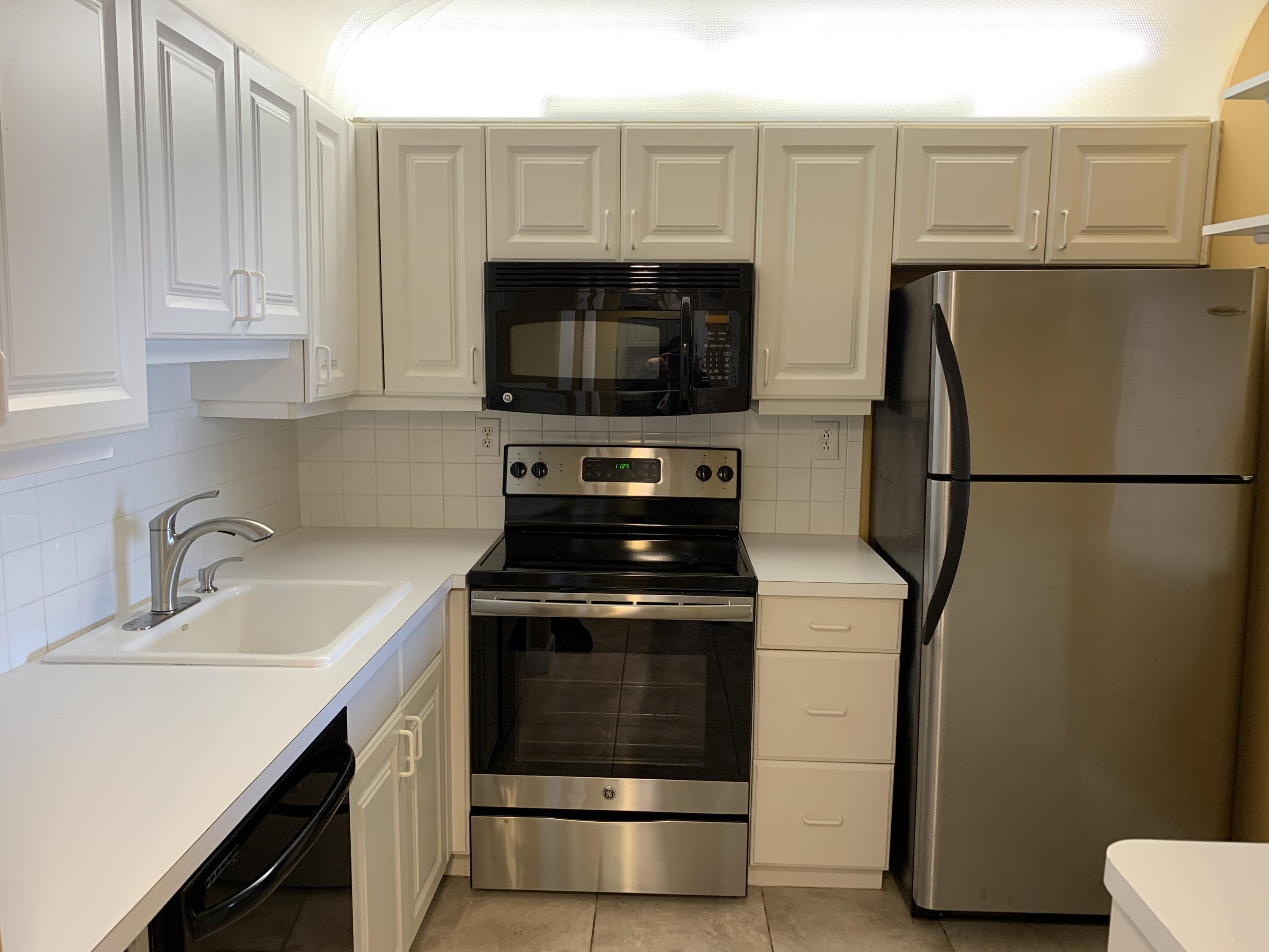 9370 Southwest 8th Street, Unit 419 Boca Raton, FL 33428 - Photo 4 of 18 a kitchen with granite countertop a sink stove and refrigerator