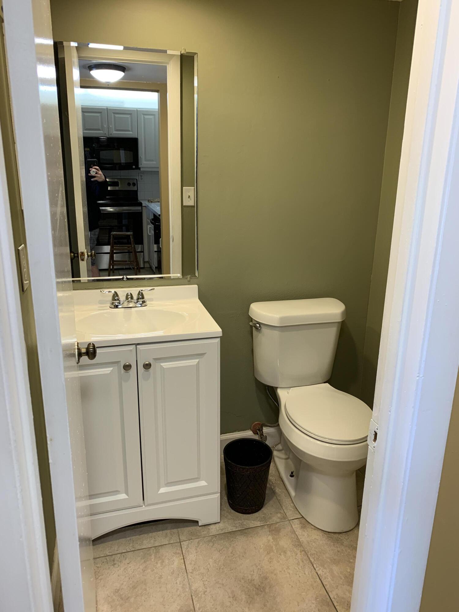 9370 Southwest 8th Street, Unit 419 Boca Raton, FL 33428 - Photo 8 of 18 a bathroom with a toilet sink and mirror