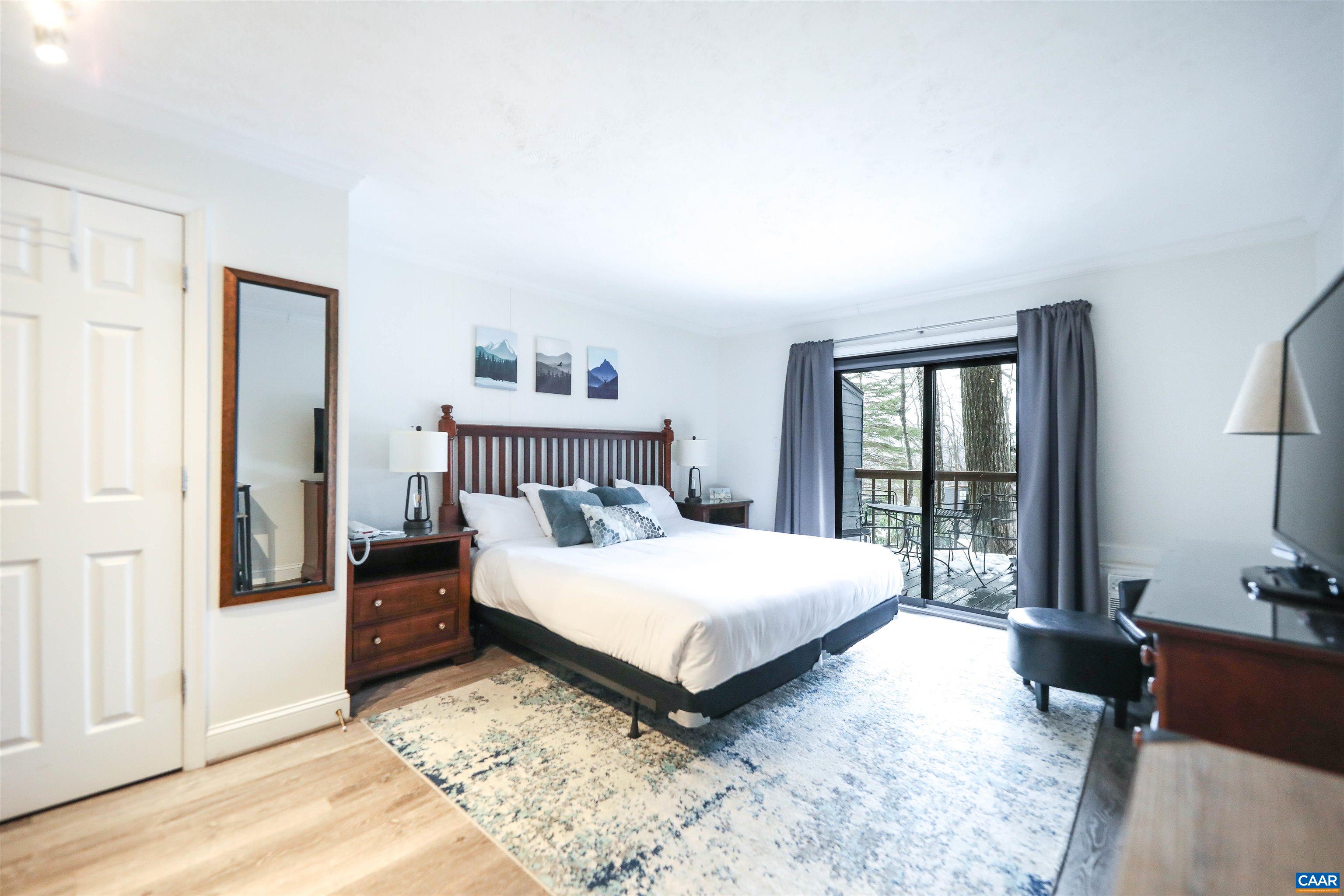 a bedroom with a bed lamp on desk and a window