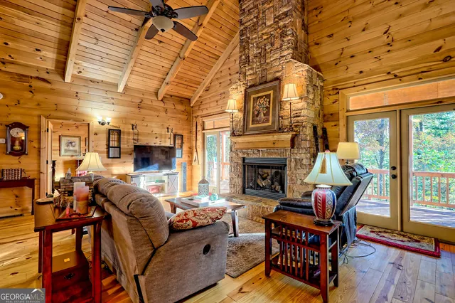 a living room with furniture a fireplace and a floor to ceiling window
