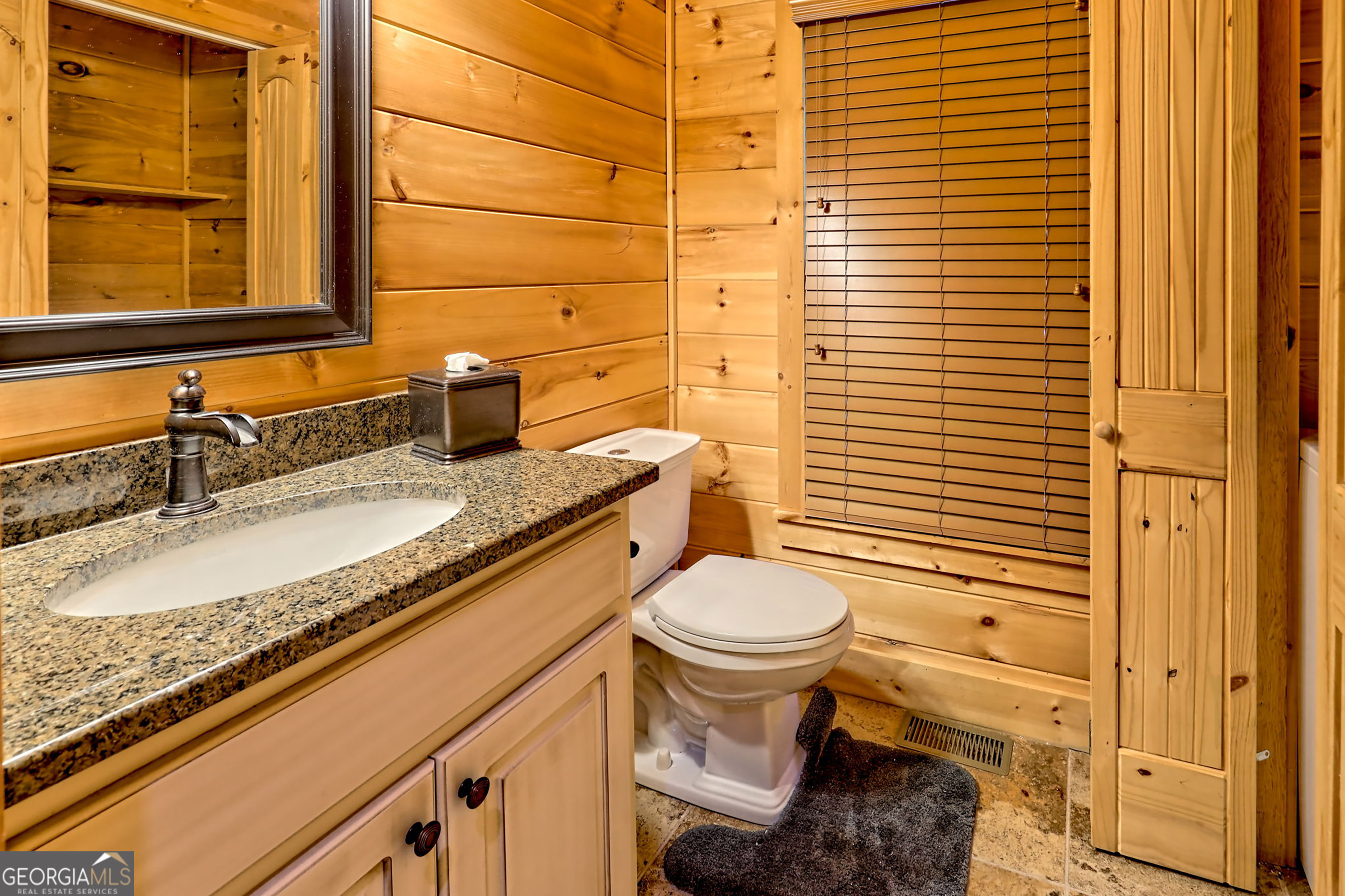407 Blackberry Drive Rabun Gap, GA 30568 - Photo 43 of 53 a bathroom with a granite countertop toilet sink and mirror