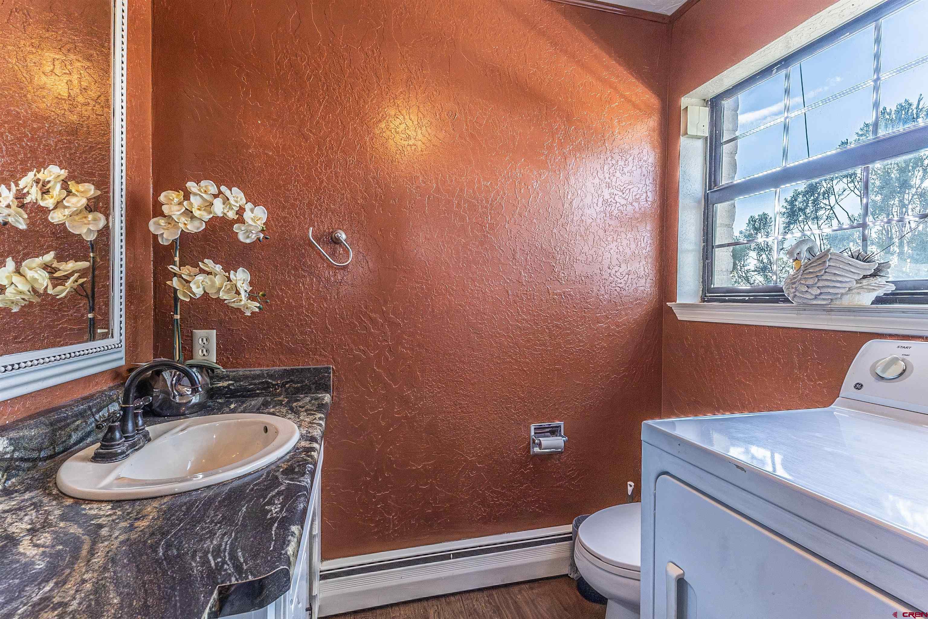5510 Rinconada Street Farmington, NM 87402 - Photo 22 of 45 a bathroom with a sink a toilet and a mirror