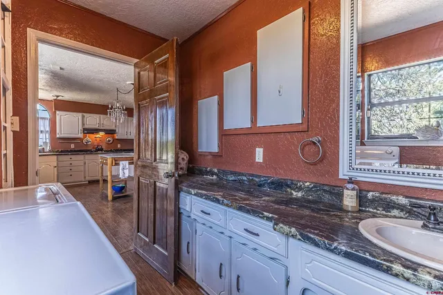 a spacious bathroom with a granite countertop sink and a large mirror