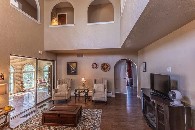 a living room with furniture a flat screen tv and a floor to ceiling window