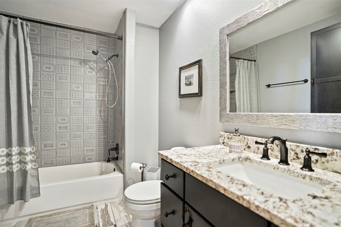 468 South Hillside Drive Silverthorne, CO 80498 - Photo 32 of 34 a bathroom with a granite countertop sink a toilet a mirror a bathtub and shower