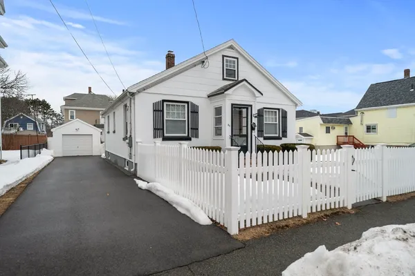 a view of a white house with wooden fence