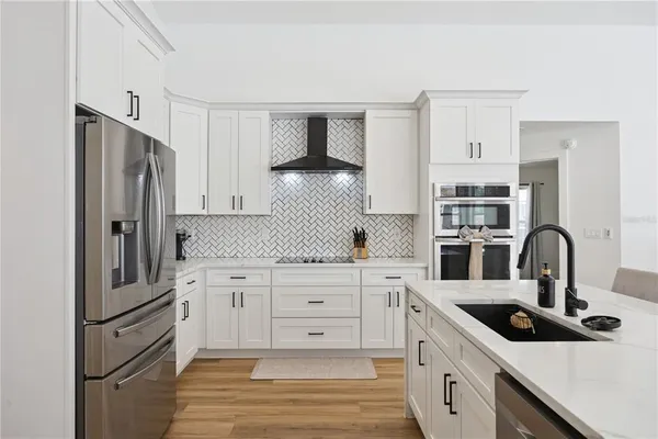 a kitchen with white cabinets and stainless steel appliances