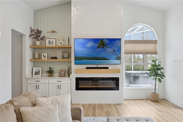 a living room with furniture a flat screen tv and a fireplace