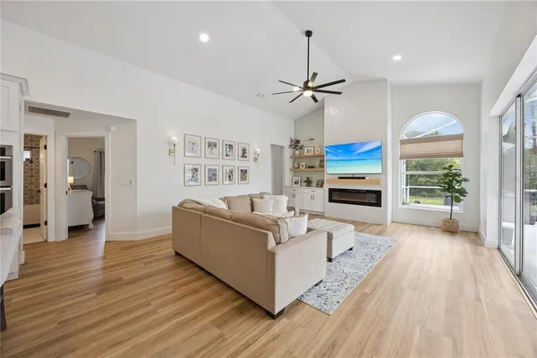 a living room with furniture and a large window with kitchen view