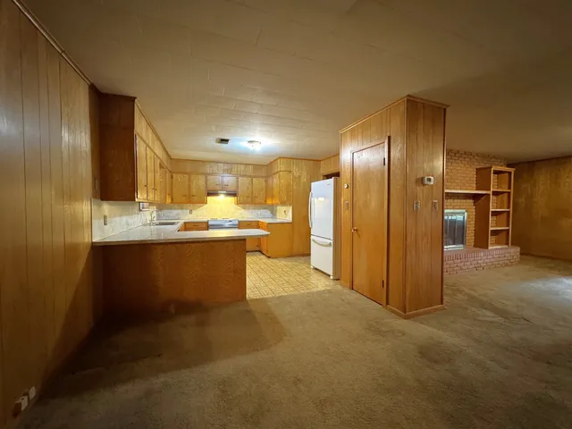 a kitchen with stainless steel appliances granite countertop a sink a refrigerator and a stove