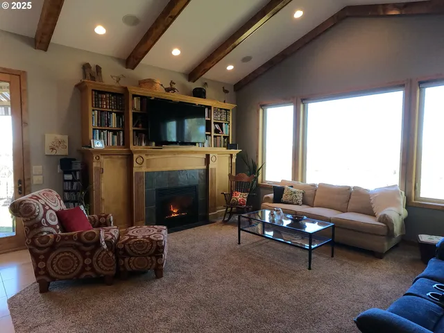 a living room with furniture a fireplace and a large window