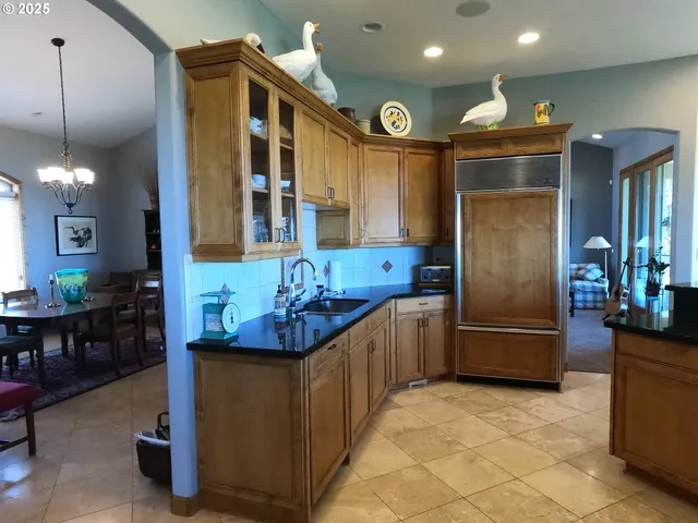 a kitchen with refrigerator and chairs