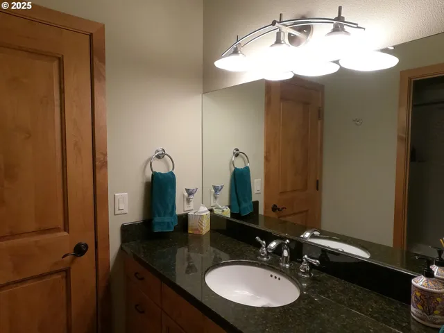 a bathroom with a granite countertop sink and toilet