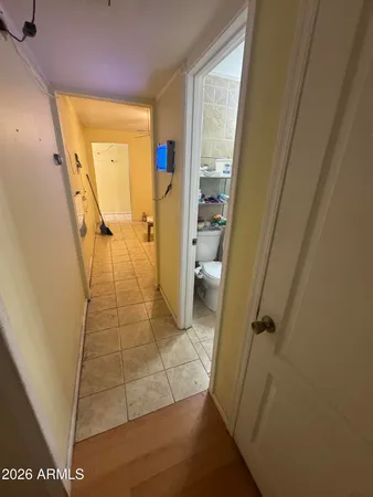a view of a hallway with wooden floor and a bathroom