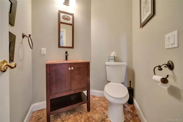 a bathroom with a toilet a sink and mirror