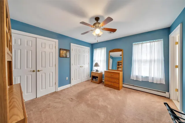 a furnished livingroom with a window and a ceiling fan