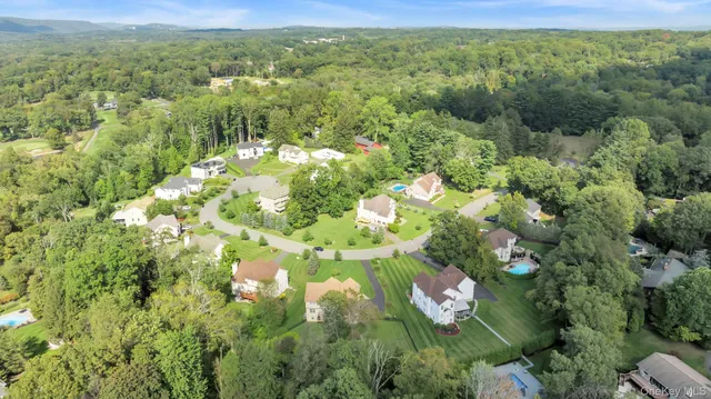 a view of a house with a big yard and large trees