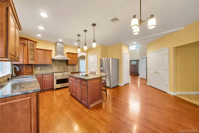 a large kitchen with granite countertop a large counter top stainless steel appliances and cabinets