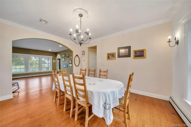 a view of a dining room with furniture wooden floor and chandelier