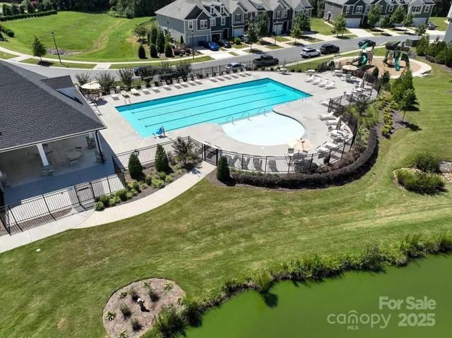 a view of a swimming pool with a yard and plants