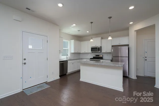 a kitchen with kitchen island a sink stainless steel appliances and cabinets