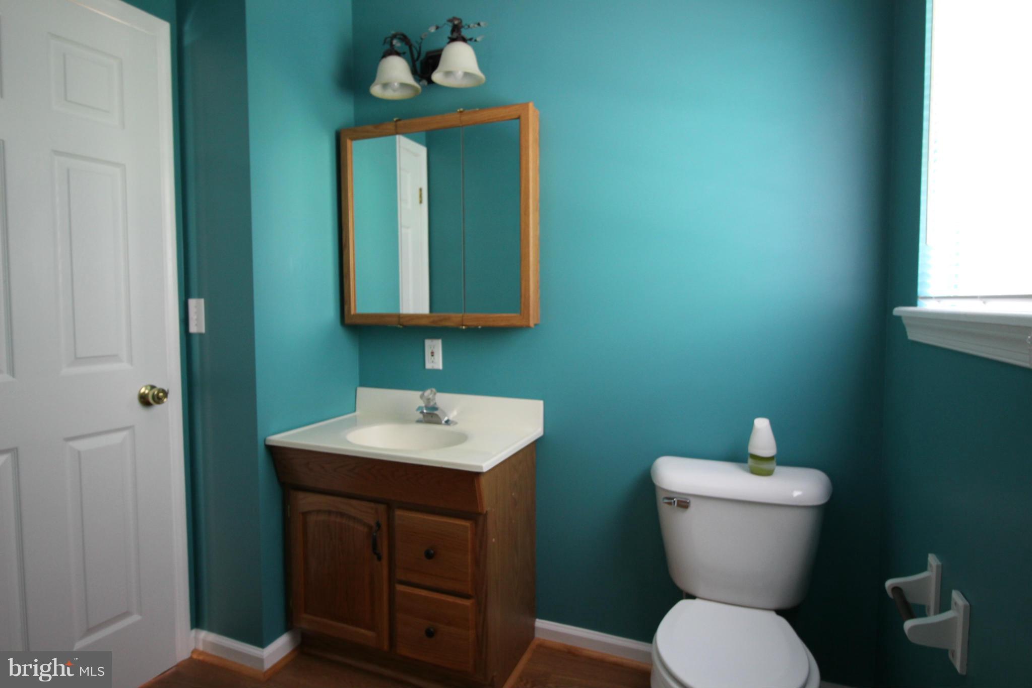 246 Windjammer Road Ocean Pines, MD 21811 - Photo 23 of 30 a bathroom with a toilet sink and mirror