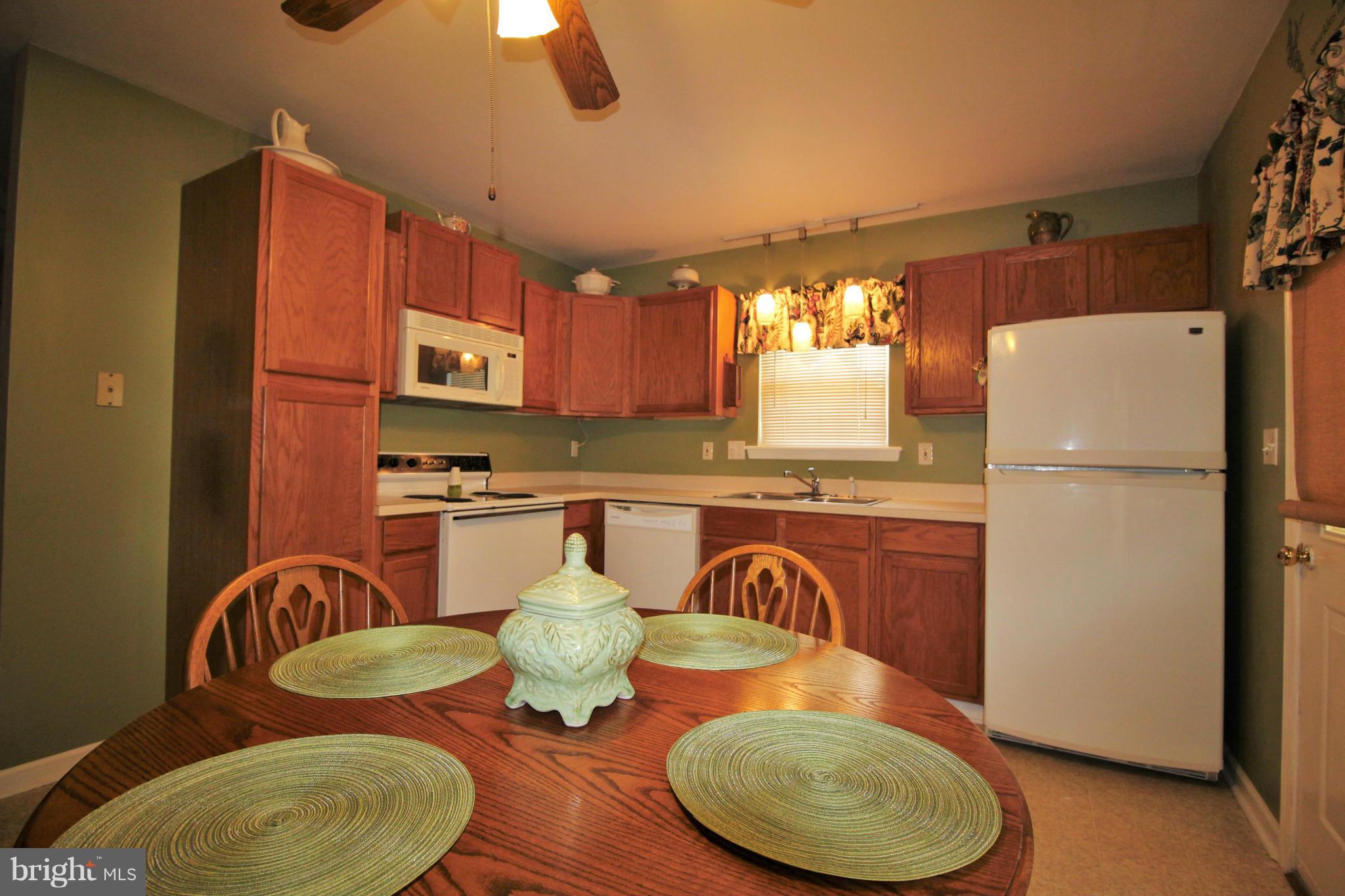 246 Windjammer Road Ocean Pines, MD 21811 - Photo 9 of 30 a kitchen with stainless steel appliances granite countertop a table chairs and a refrigerator