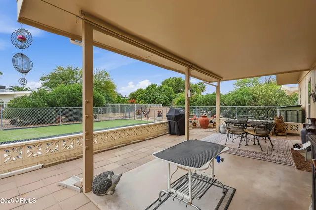 a view of a chairs and table in patio with a yard