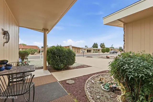 a view of a terrace with furniture and a floor to ceiling window