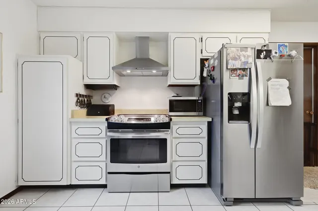 a kitchen with stainless steel appliances a refrigerator stove and cabinets