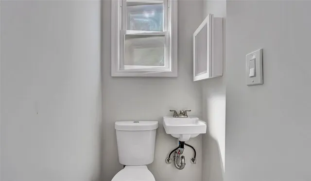 a bathroom with a sink toilet and a mirror