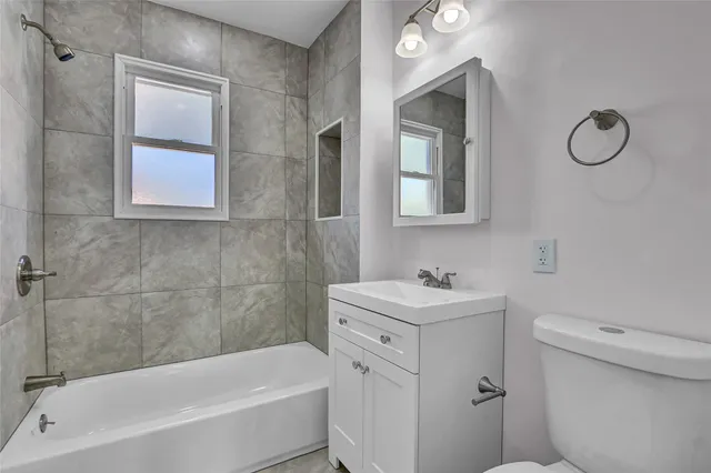 a bathroom with a sink mirror toilet and bathtub