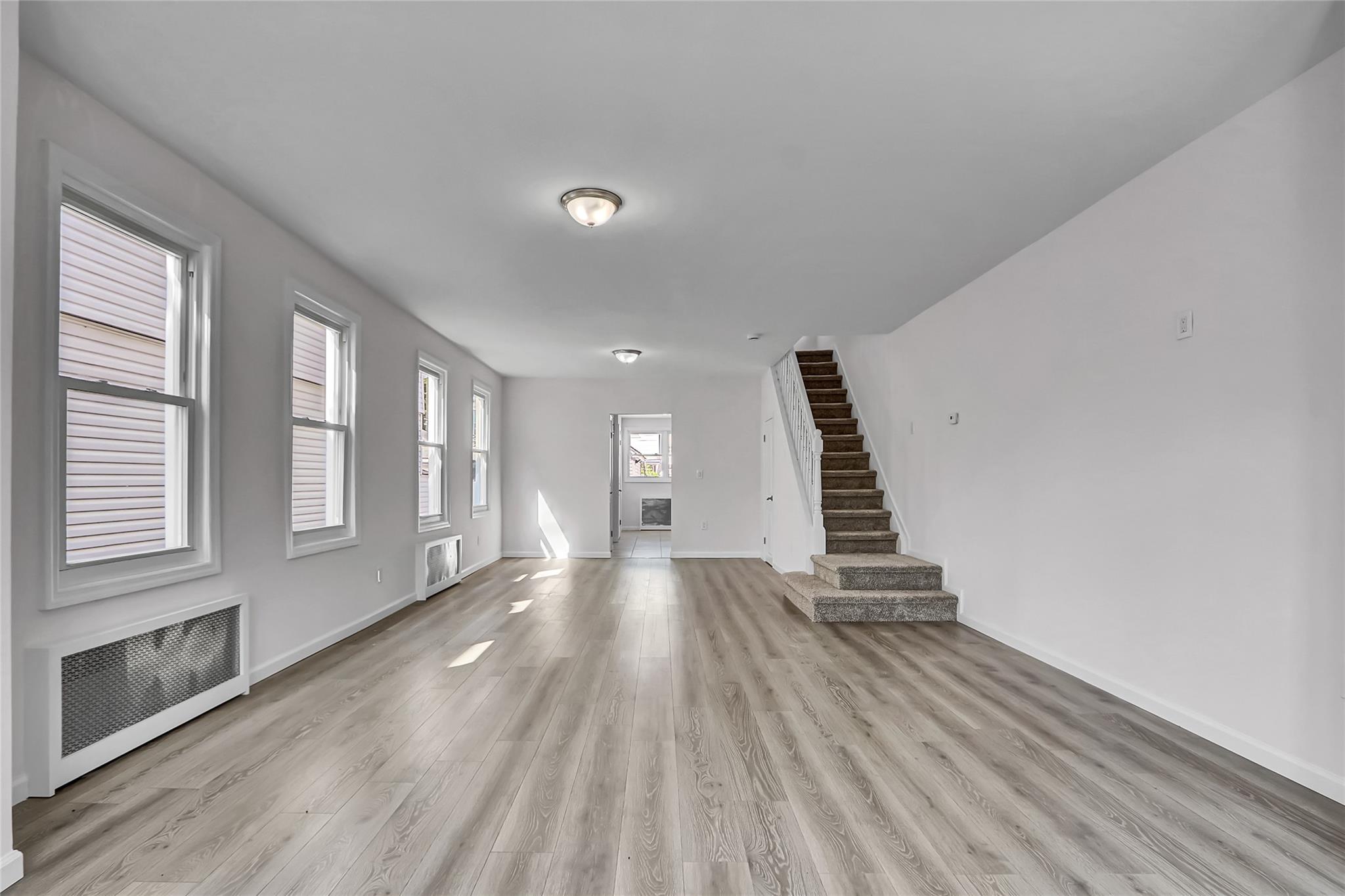 111-32 116th Street Queens, NY 11420 - Photo 4 of 18 a view of an empty room with wooden floor and windows