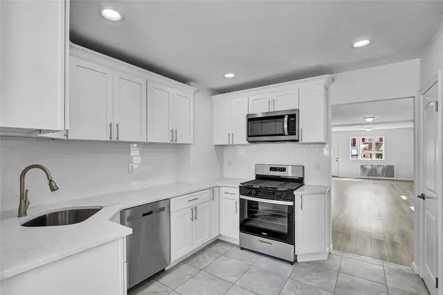 a kitchen with sink a microwave and cabinets