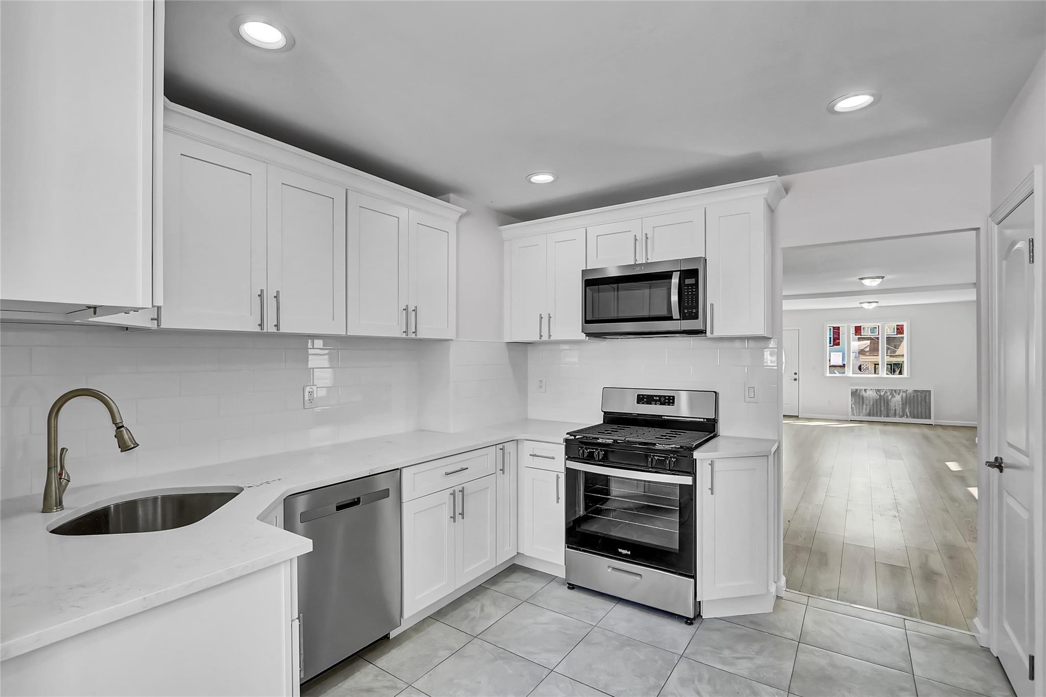 111-32 116th Street Queens, NY 11420 - Photo 7 of 18 a kitchen with sink a microwave and cabinets