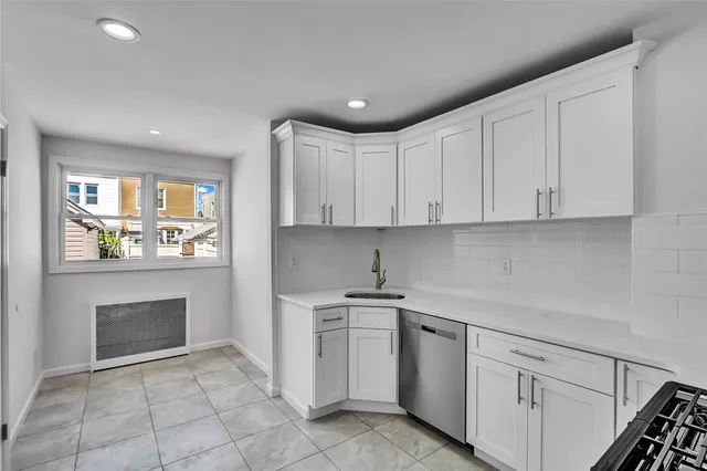 a kitchen with white cabinets and appliances