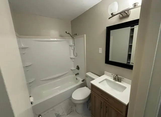 a bathroom with a sink toilet and shower