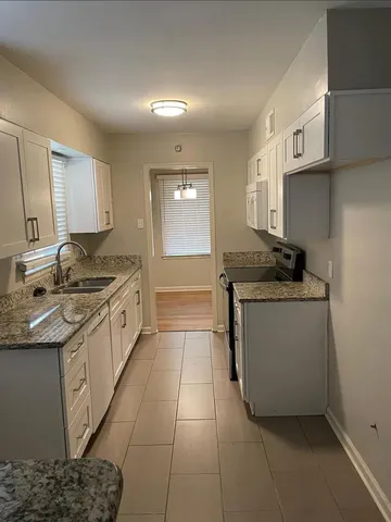 a kitchen with stainless steel appliances granite countertop a sink stove and cabinets