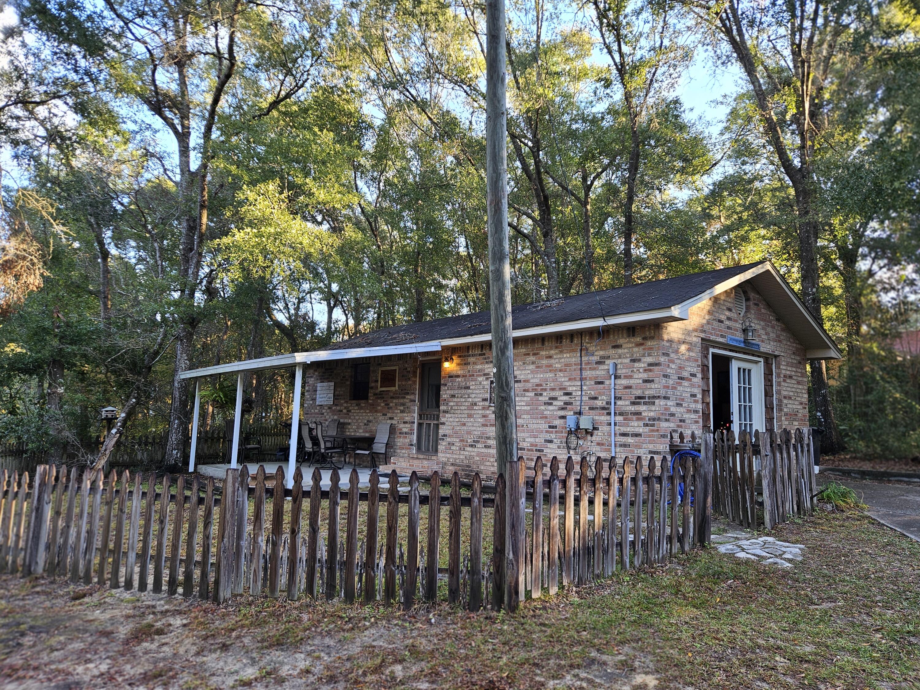 108 Mohawk Trail Crestview, FL 32536 - Photo 34 of 39 a view of wooden house with a small yard and large trees
