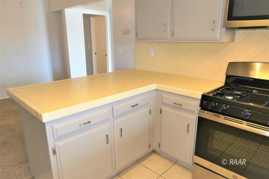 332 Larkspur Street Ridgecrest, CA 93555 - Photo 7 of 28 a kitchen with white cabinets and appliances