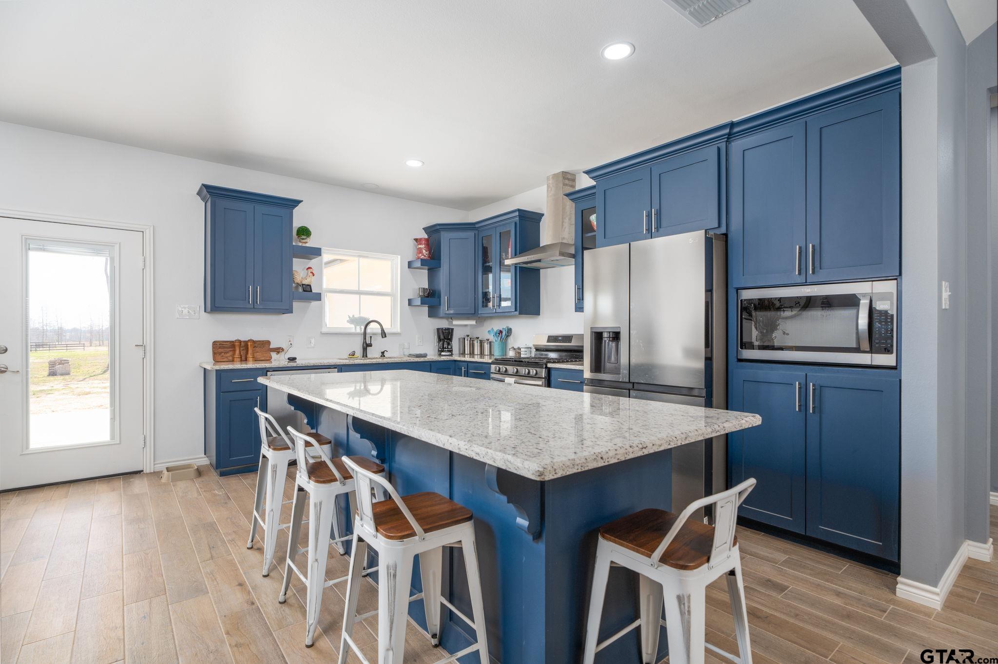4356 Buie Road Diana, TX 75640 - Photo 7 of 29 a kitchen with stainless steel appliances granite countertop a table chairs sink refrigerator and cabinets
